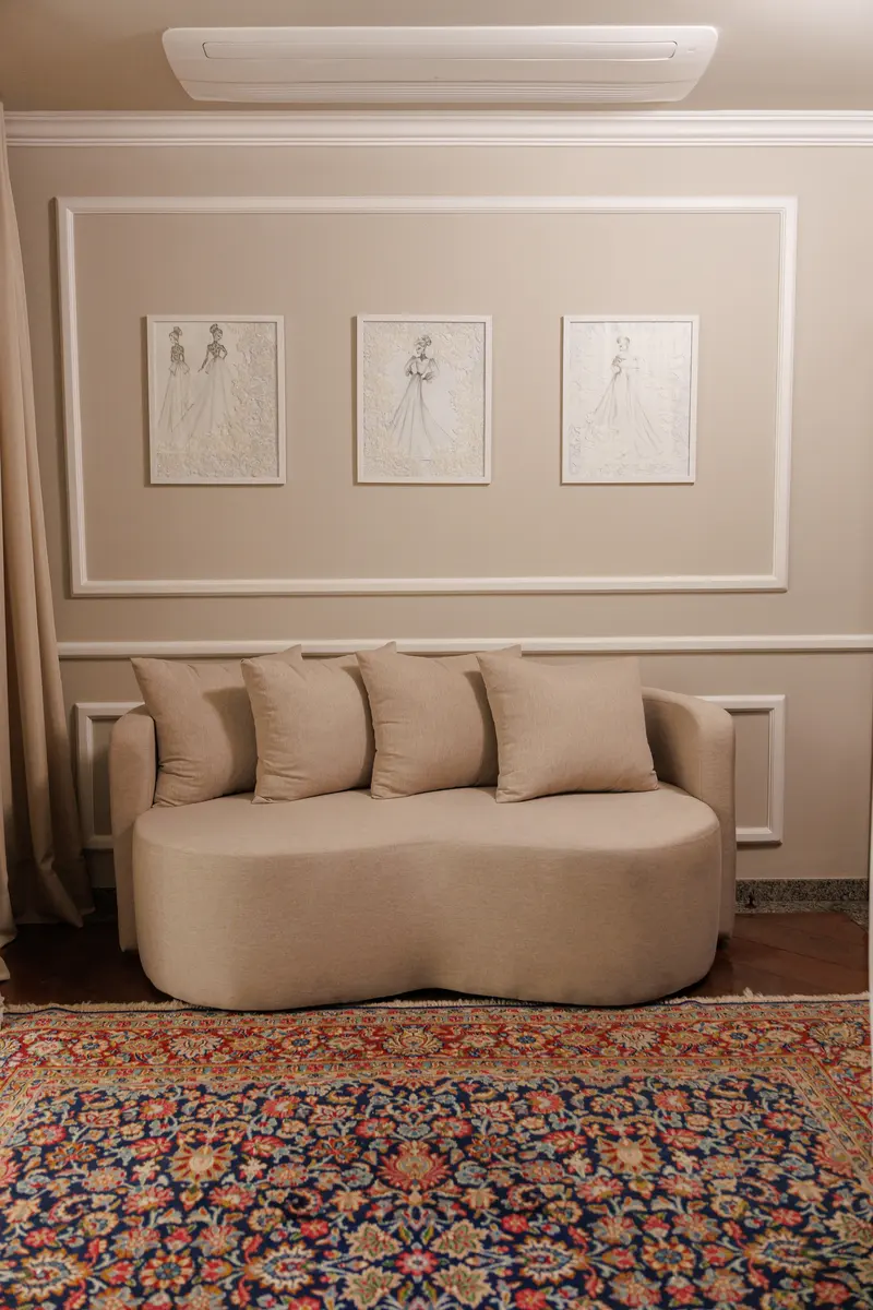 A sala de estar de boiserie, com os croquis emoldurados na parede.