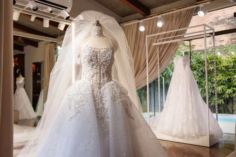 Vestido bordado com véu, no manequim do salão.
