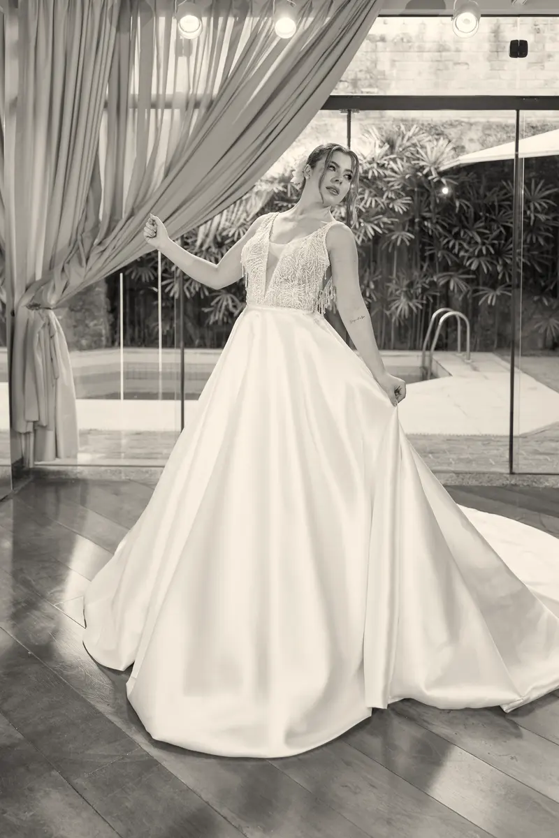 Noiva de vestido com decote em V, de corpo inteiro.