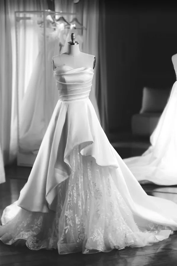 Vestido de noiva no manequim, em preto e branco, com saia assimétrica sobre renda.